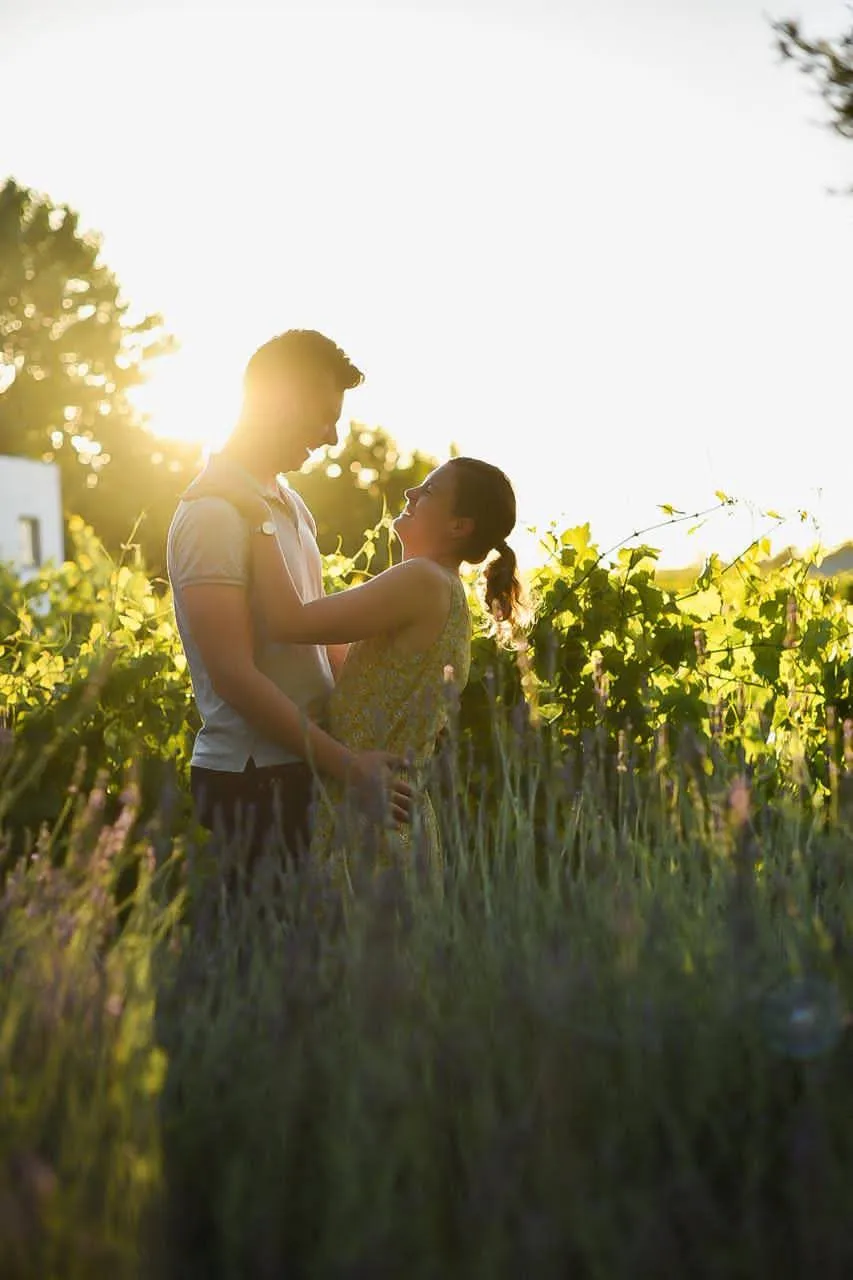 Couple embracing at sunset among the vines and lavender